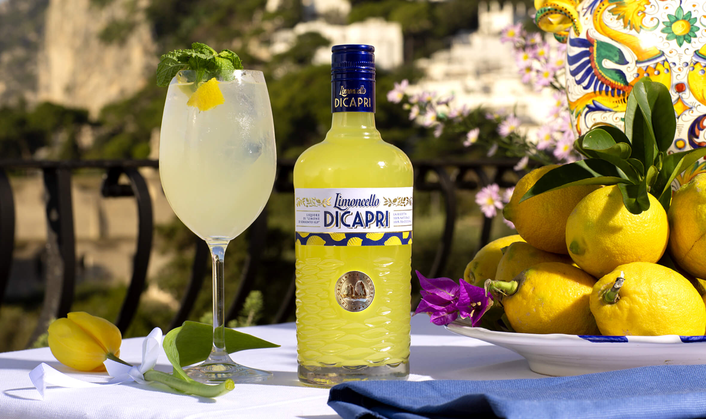 Limoncello di Capri - bottiglia e cocktail con limoni e maioliche