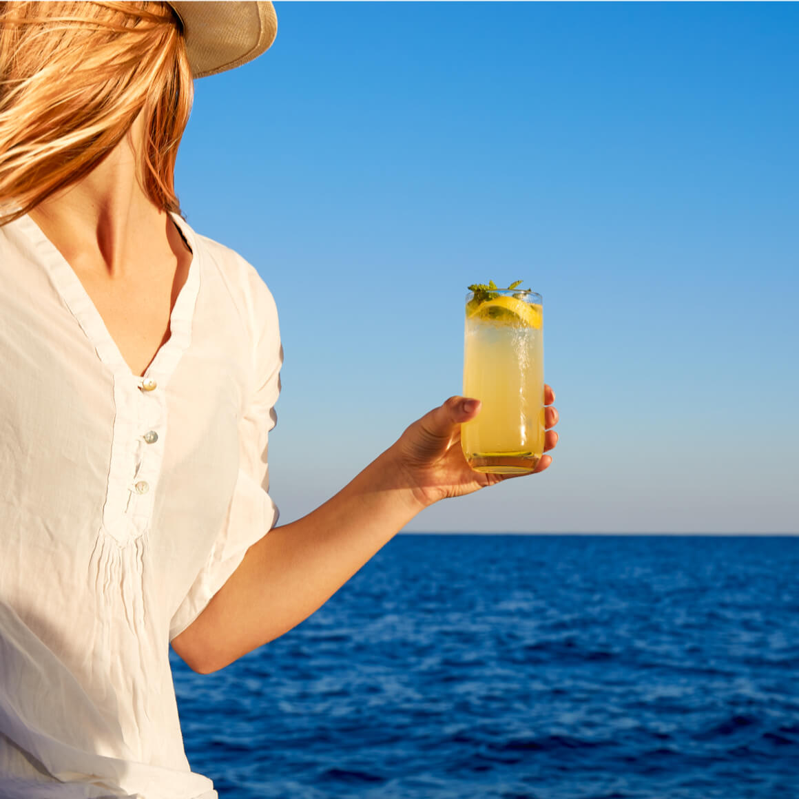 Limoncello di Capri ragazza con cocktail in mano sul mare