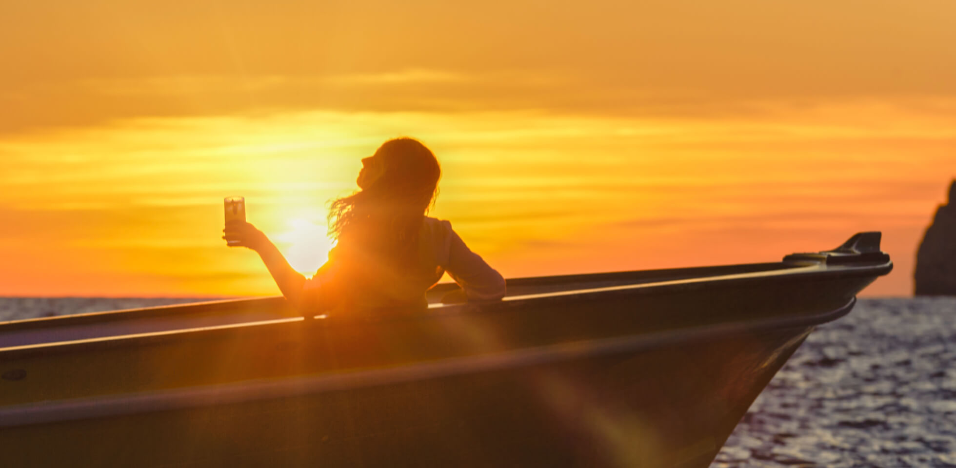 Limoncello di Capri_ragazza in barca al tramonto con cocktail